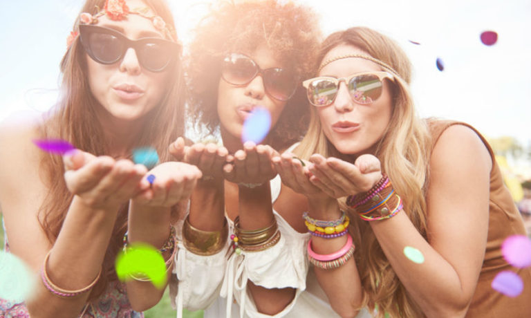 Drei Frauen auf einem Festival mit bunten Accessoires