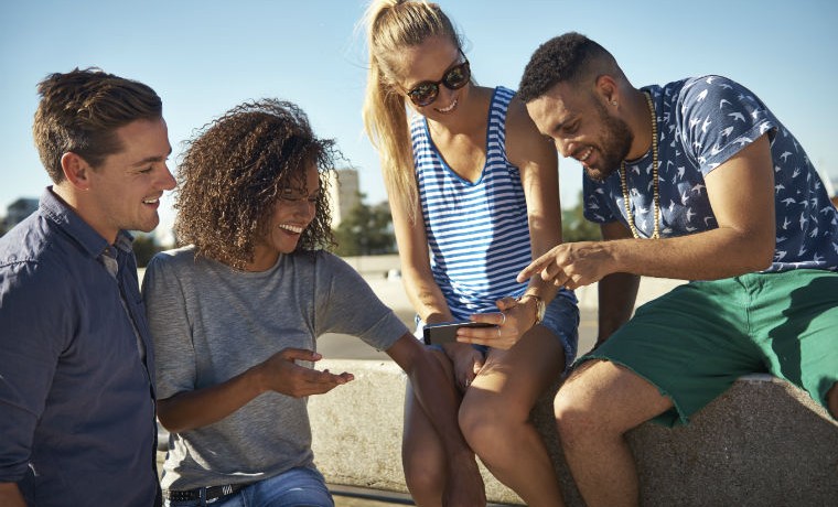 Hipster sitzen zusammen und schauen ein Video auf dem Smartphone