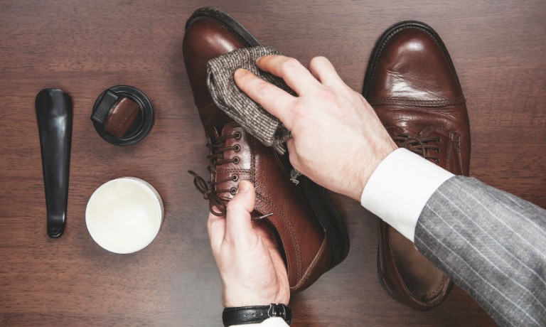 braune Lederschuhe werden von Hand gepflegt