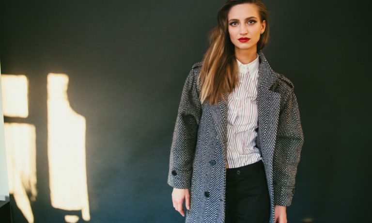 Frau in Mantel und Bluse mit Muster