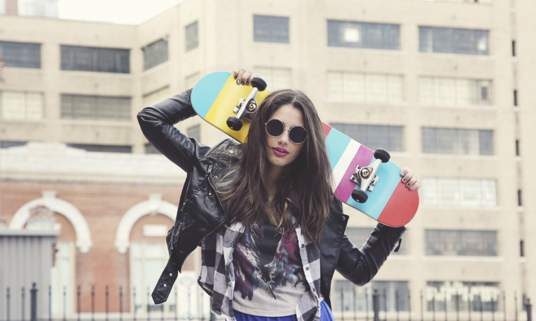 Teenager mit Skateboard und Lederjacke