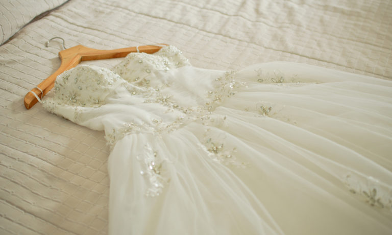 Weißes Hochzeitskleid auf weißem Bettlacken