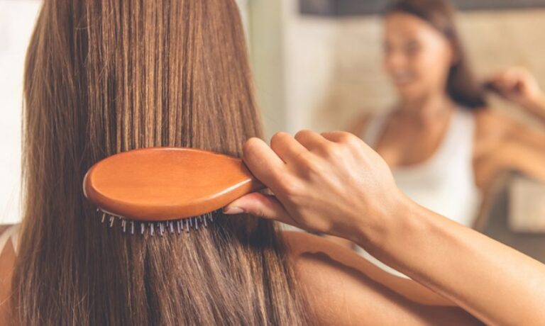 Frau kämmt ihre Haare