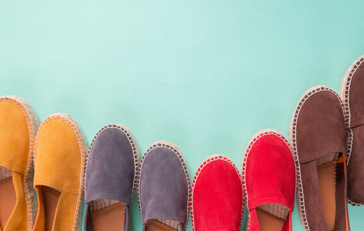 4 Paar Slipper in Gelb, Blau, Rot und Braun auf türkisem Hintergrund