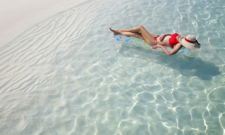 Frau im Bikini sonnt sich auf dem Meer